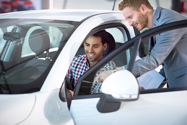 man looking at new car